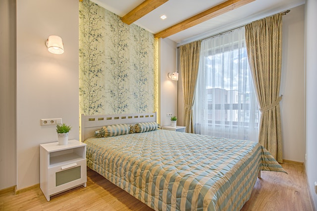 a bedroom with a striped bedspread and floral wallpaper